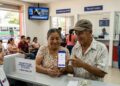 Una pareja de salvadoreños se observa en una oficina de remesas recibiendo sus fondos.