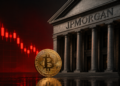 Moneda de BTC y velas en rojo.