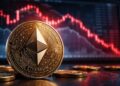 Moneda física de Ethereum frente a gráficos bursátiles en caída, simbolizando la crisis y baja del precio de ETH.