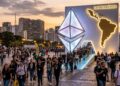 Personas saliendo de un logo de Ethereum gigante, con silueta de Latinoamérica.