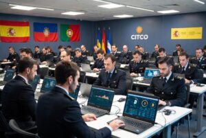 Agentes policiales aparecen sentados cada uno frente a una computadora en la que se observa información sobre bitcoin y criptomonedas