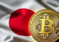 Una moneda de bitcoin sobre la bandera de Japón.