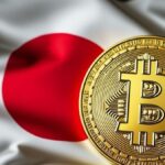 Una moneda de bitcoin sobre la bandera de Japรณn.