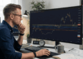 Trader mirando gráfico de precio con próximos soportes en el monitor de su computadora.