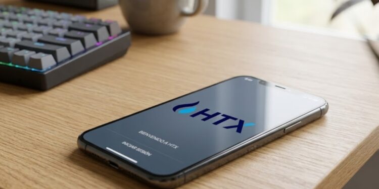 Teléfono sobre una mesa de madera que muestra en su pantalla el logo de HTX.