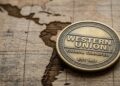 Moneda que tiene grabado el logo de Western Union. Con la silueta de Latinoamérica de fondo.