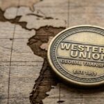 Moneda que tiene grabado el logo de Western Union. Con la silueta de Latinoamérica de fondo.