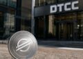 En primer plano: moneda física de Stellar (XLM). En el fondo: edificio corporativo de DTCC.