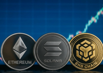 Monedas con el logo de ethereum, solana y BNB sobre un grafico de mercado