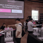 Representación de una votación en un centro físico, con personas depositando sus votos en urnas, generada por inteligencia artificial.