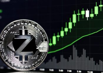 Moneda física de zcash en primer plano con un gráfico de precios alcista en verde de fondo.