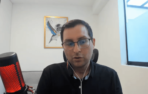 Fotografía de primer plano del abogado especialista en criptoactivos Adolfo Morán durante una entrevista. Se le observa en un ambiente profesional de oficina, vistiendo sweter negro y mirando hacia abajo en expresión reflexiva.
