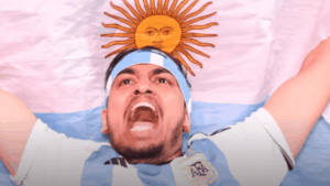 Aficionado argentino con bandera y bandana celeste y blanca en la cabeza, celebrando antes de un partido del Mundial 2026.