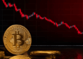 Moneda de bitcoin y gráfico de precios rojo cayendo.