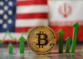 Primer plano: moneda de bitcoin y flechas verdes. Fondo: banderas de EE. UU. e Irán.