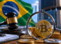 Bandera de brasil sobre un escritorio con una lupa y moneda de bitcoin y criptomonedas