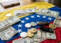 USDT y dólares sobre la bandera de Venezuela.