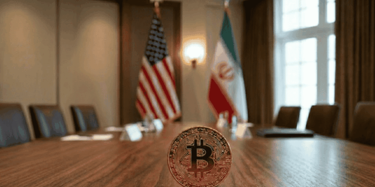 Primer plano: moneda de bitcoin sobre una mesa. Fondo: banderas de EEUU e Irán.