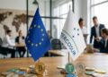 Banderas de la UE, el Mercosur. Con criptomonedas físicas como bitcoin y stablecoins alrededor.