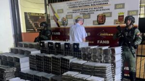 Fotografía de funcionarios de la GNB junto a un detenido y cientos de mineros ASIC.