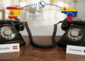 Dos teléfonos conectados entre sí, uno tiene un letrero que dice "España", el otro tiene un letrero que dice "Venezuela".