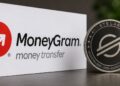 El logo de Moneygram junto a una moneda física de stellar.
