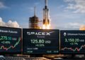 Pantallas de trading muestran futuros de SpaceX junto a bitcoin y Ethereum, con un cohete despegando al fondo.