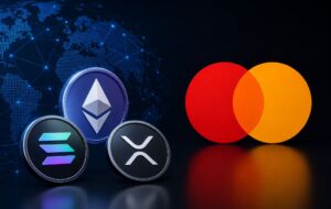 Monedas físicas de Ethereum, Solana y XRP junto al logo de Mastercard.