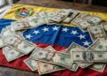 Billetes de dólares de distintas denominaciones sobre la bandera de Venezuela.