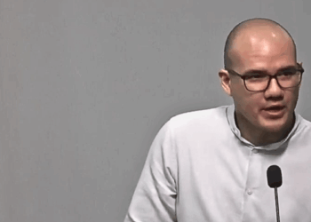 Rodrigo Icaza, hombre calvo con lentes de marco negro, viste camisa blanca y habla ante un micrófono durante una conferencia.