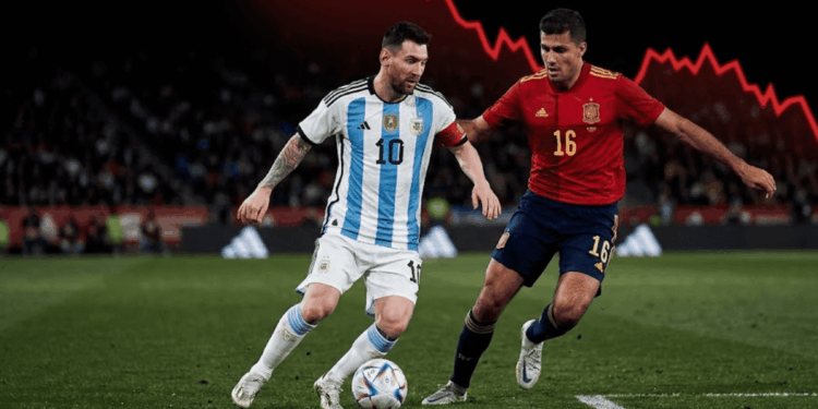 Lionel Messi con la camiseta de Argentina y Rodrigo Hernández con la de España disputan el balón en un partido de fútbol, mientras en el fondo negro destaca un enorme gráfico rojo de caída financiera.