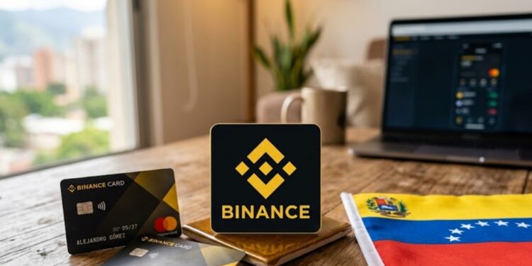 Logo de Binance junto a una tarjeta de débito y la bandera de Venezuela sobre una mesa.