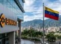 Logo de Binance, y al lado, la bandera de Venezuela, hacia en el fondo