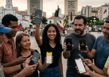 Personas en Caracas mostrando la aplicación de Binance en sus teléfonos móviles.
