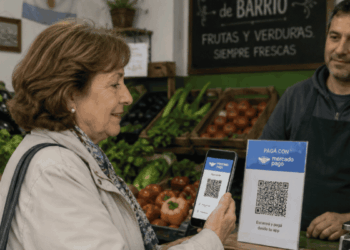 Mujer pagando en una verdulería con un código QR de MercadoPago.