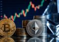 Monedas de Bitcoin y Ethereum frente a un gráfico bursátil de criptomonedas.