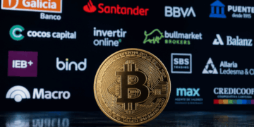 Primer plano: moneda física de bitcoin. Fondo: logos de diversos bancos y entidades financieras de Argentina.