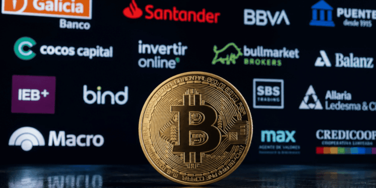 Primer plano: moneda física de bitcoin. Fondo: logos de diversos bancos y entidades financieras de Argentina.