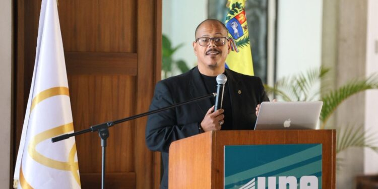 Foto de Aaron Olmos halando en un podio en un evento.