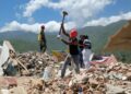 Fotografía de rescatista golpeando escombros para salvar personas o recuperar cuerpos en La Guaira, Venezuela, tras los terremotos.