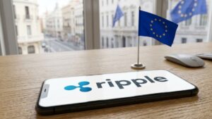 Teléfono inteligente sobre una mesa que en pantalla aparece el logo anexado junto a una bandera de la UE.