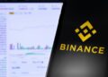 Mano sujetando un teléfono inteligente que muestra el logo de Binance.