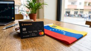 Una tarjeta de Binance con la bandera de Venezuela al lado, sobre una mesa.