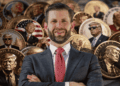 Primer plano: Eric Trump. Fondo: muchas monedas con imágenes de Donald Trump.