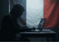 Un hacker. De fondo, la bandera de Francia.