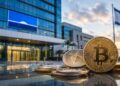 Monedas de Bitcoin y Ethereum frente a un edificio de oficinas moderno en Israel.