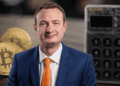Fotografía de Tim Lamb, monedas físicas de bitcoin y una hardware wallet Coldcard.
