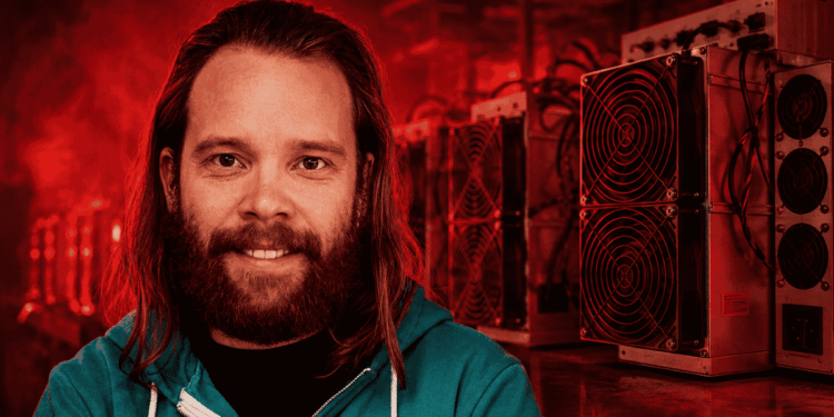 Michael Schmid delante de equipos de minería de Bitcoin.