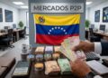 Brazos de hombre sosteniendo billetes venezolanos, con stablecoins sobre una mesa, con la bandera de Venezuela y la frase "Mercados P2P" en el fondo.