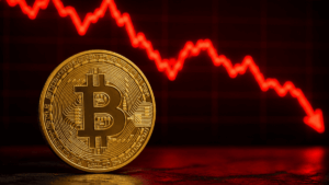 Moneda de bitcoin y flecha roja descendente.